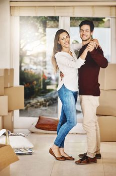 Buying a house together is a big deal. Full length portrait of an affectionate young couple dancing while moving into a new home.