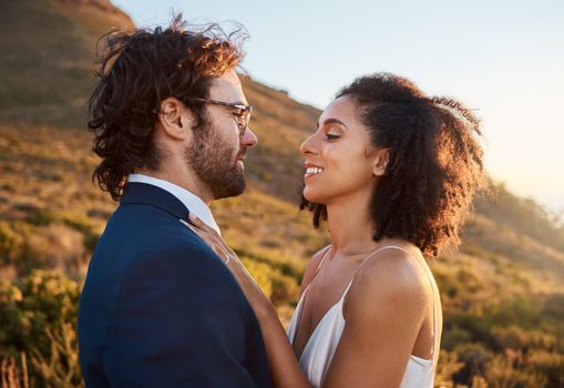Wedding, trust and bride with groom on mountain for marriage ceremony, commitment and celebration. Love, intimate embrace and happy interracial couple hug on romantic vacation, honeymoon and holiday
