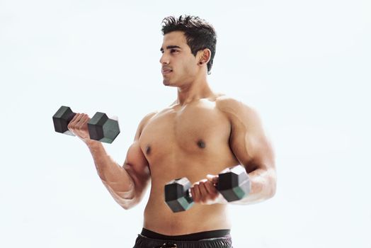 Theyre not going to lift themselves. a shirtless young man working out with dumbbells outside.