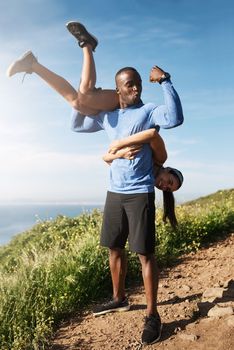 Strong guys get the good chicks. a muscular man carrying his girlfriend over his shoulders.