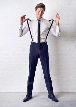 Adding a touch of style. Full length shot of a well dressed young man in suspenders.