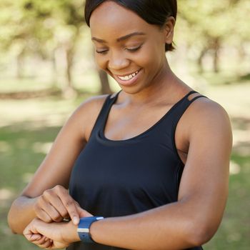 Fitness, watch and runner with a sports black woman in the park for cardio exercise or endurance fitness. Health, app and training with a female athlete tracking her run or progress on a smartwatch