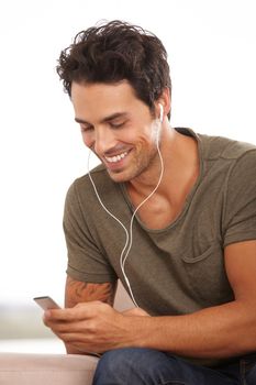 I love this song. A handsome young man listening to music on his mp3 player isolated on white.
