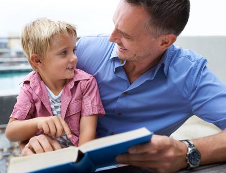 I love it when dad reads to me. a father reading to his little boy.