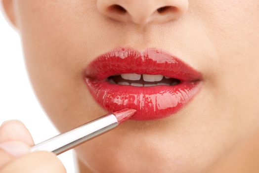 Irresistible lips. an attractive young woman applying red lip gloss.