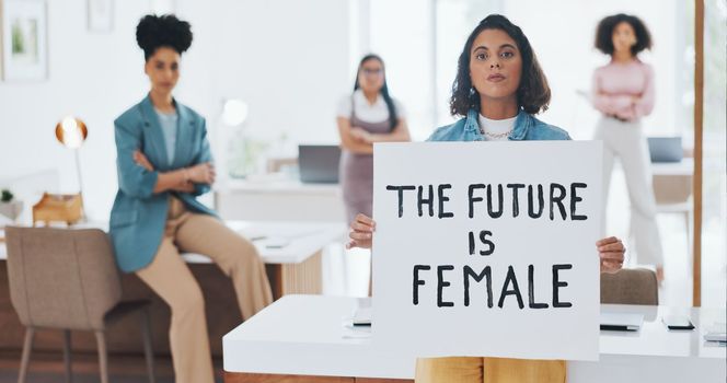 Equality, empowerment and female leader holding a sign in the office with her business woman group at work. Future, human rights and diversity with a feminism team working for revolution or change