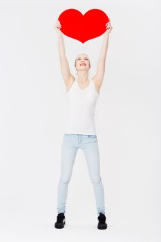 Woman, studio and holding cardboard heart with happiness for valentines day celebration by white background. Isolated model, excited and smile with poster for romance, love and dating with happiness
