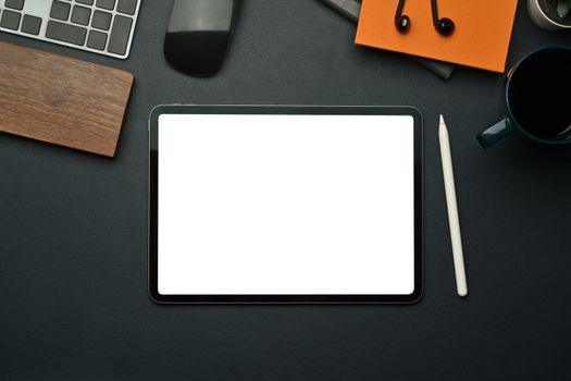 Flat lay digital tablet with empty screen, stylus pen, notebook and coffee cup on black leather