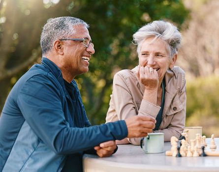 Happy, chess or couple of friends in nature playing a board game, bonding or talking about a funny story. Park, support or healthy senior people laughing at a joke and enjoying quality relaxing time