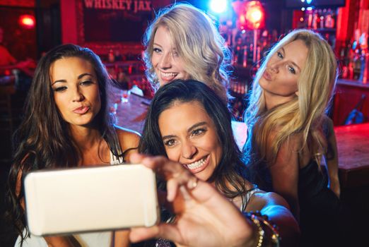 Friends, party and selfie at a club, bar or fun event to celebrate new years, birthday and nightlife while together with smile. Female group at nightclub for celebration and holding phone for memory
