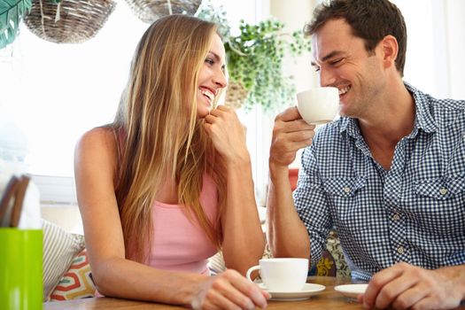 Coffee shop conversation. An attractive young couple enjoying a cup of coffee in restaurant.