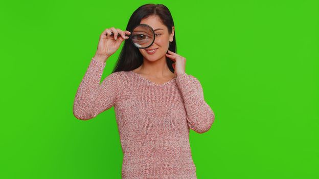 Investigator researcher woman with magnifying glass near face, looking into camera with big zoom eye
