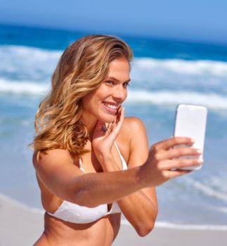 To you - beach selfie. A beautiful, young woman having fun at the beach.