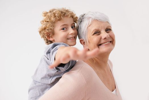 Fun with granny. a grandmother giving her grandson a piggyback ride.