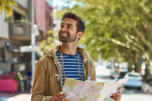 Keep calm and travel on. a happy tourist using a map to explore a foreign city on his own