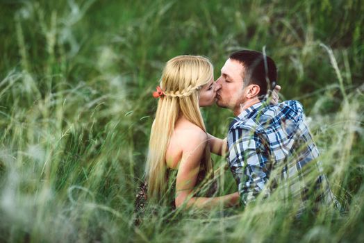 couple in love blonde girl and guy in the grass