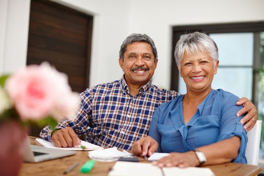 Weve insured our retirement with wise financial planning. a happy senior couple working on their budget together at home.