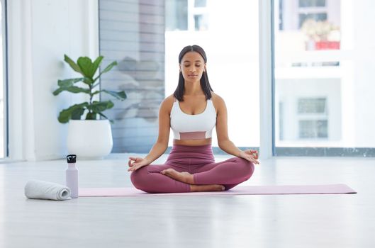 Calm the mind completely. a sporty young woman meditating while exercising in a yoga studio.