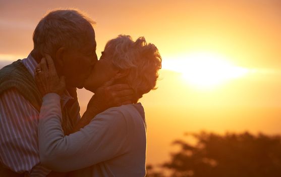Treasure these moments. an elderly couple sharing a romantic moment at sunset.