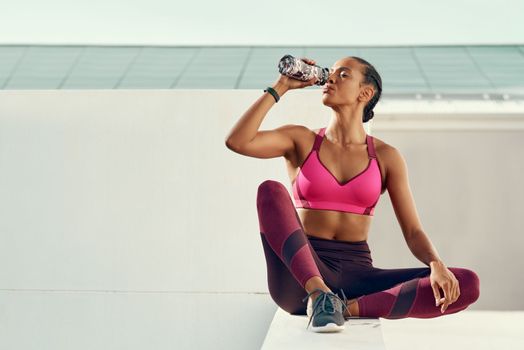 Theres nothing your body need as much as water and exercise. a sporty young woman drinking water while resting.