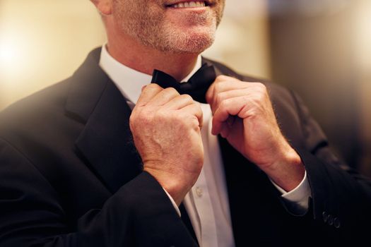 Hands, wedding and bow tie with a groom getting ready for his marriage ceremony of tradition or celebration. Fashion, event and celebrating with a man wearing a suit as a gentleman to be married