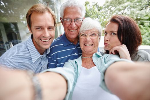 Family is as family does. four adults taking a family selfie.