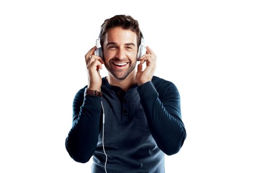 The sound on these headphones are awesome. Studio portrait of a handsome young man using headphones against a white background.