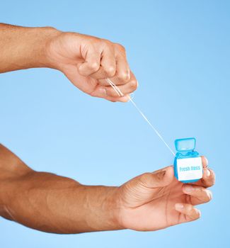 Floss, dental healthcare and man hands with product container on studio mock up for teeth, mouth and dentist cleaning marketing. Medical, wellness and dental floss health care with blue mockup