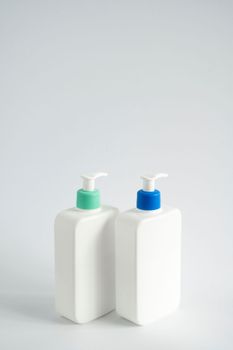White blank plastic bottles with dispenser pump for gel, liquid soap, lotion, cream, shampoo on white background. Cosmetics.