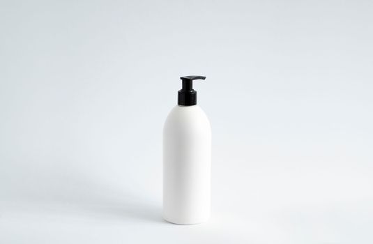 White blank plastic bottle with black dispenser pump for gel, liquid soap, lotion, cream, shampoo on white background. Cosmetics.