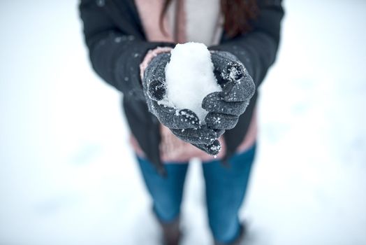 Theres something magical about snow. an unrecognizable woman holding snow in her hands.