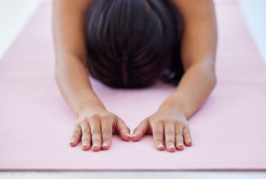 Create a calming oasis for yourself. Closeup shot of an unrecognisable woman doing childs pose while exercising in a yoga studio.