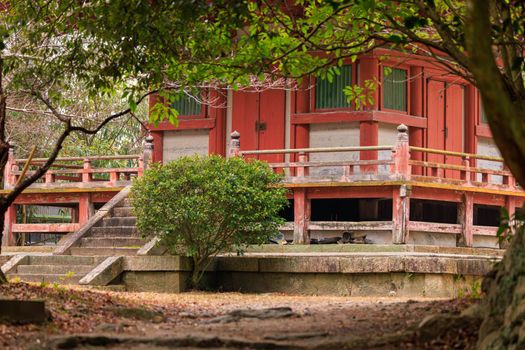 Small stairs and red building on natural grounds of Taisanji Temple