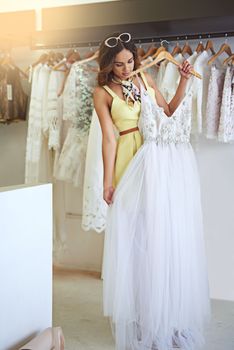 Shopping for a wedding dress is a once-in-a-lifetime experience. an attractive young woman searching for a wedding dress.