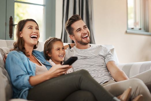 Perfect weekends are about being with the people you love. a happy young family relaxing on the sofa and watching tv together at home.