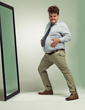 Im a sexy beast. an excited overweight man celebrating while looking in a mirror.
