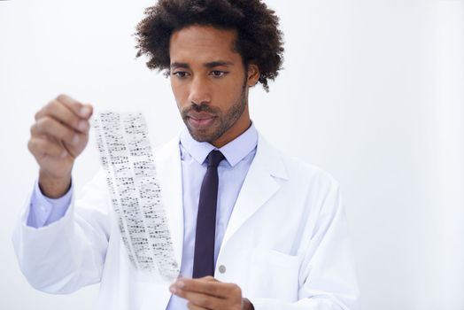 Everyones DNA signature is different. a handsome male scientist analyzing a printout of DNA signatures.