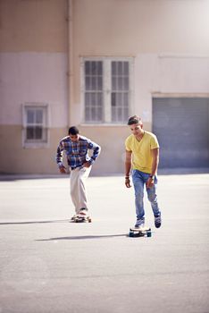 Skateboarding is a part of their lifestyle. two young men skateboarding at a skate park.