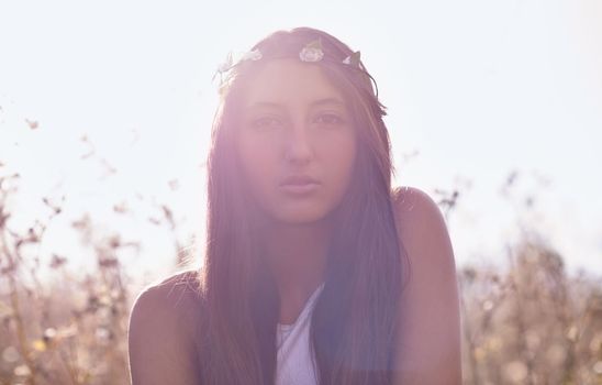 On a journey to self-discovery. Portrait of an attractive teenage girl in a field with the sun behind her.
