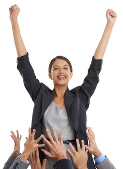 Shes always ahead of the pack. Studio shot of a young businesswoman cheering in victory with the hands of her colleagues surrounding her.