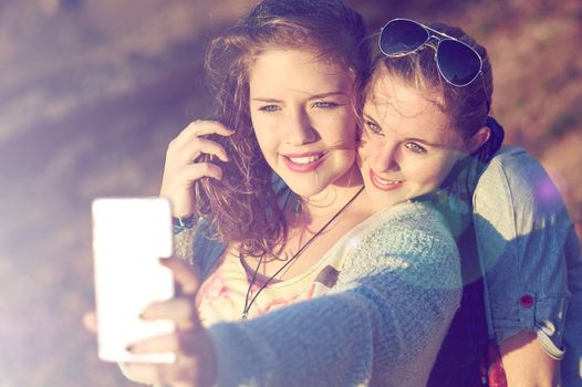 Capturing best friend moments. two teenage girls taking a selfie outdoors.