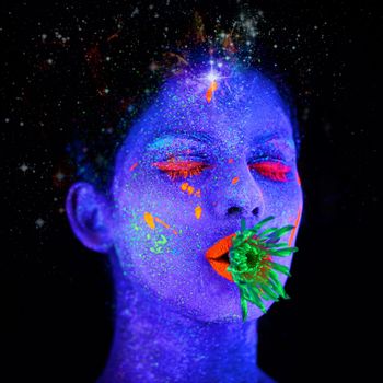 Fluorescent fantasy. a young woman posing with neon paint on her face.