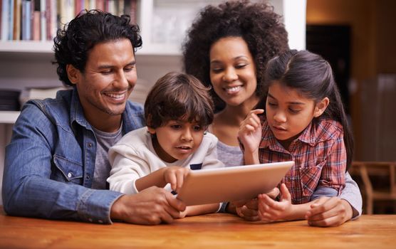 Look at that. a happy young family using a digital tablet at home.