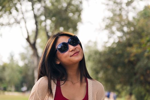 young asian woman in sunglasses smiling playful