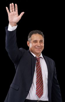 A friendly wave. A politician in a suit waving while on a black background.