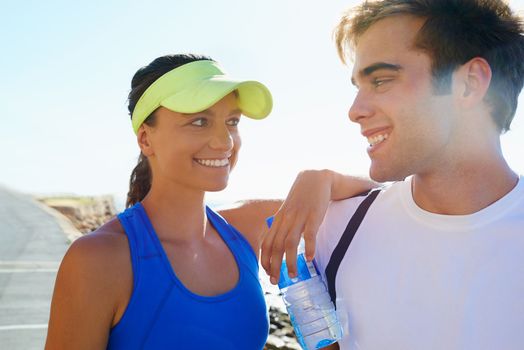 They share an interest in fitness. A young athletic couple standing outside.