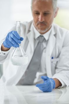 Lets mix things up a bit. a researcher working with beakers in a lab.