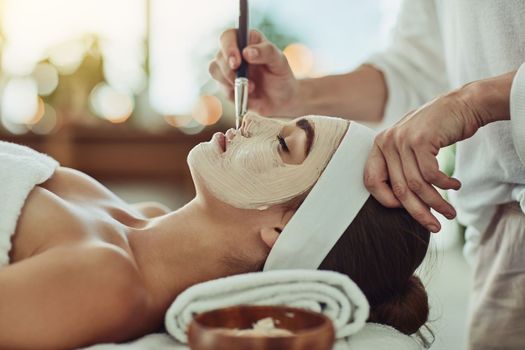 Pamper your gorgeous self. an attractive young woman getting a facial at a beauty spa.