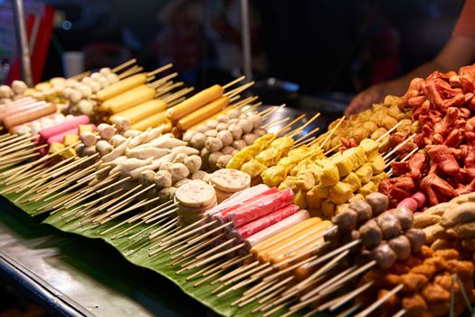 A counter with different kinds of satey. Street food market in Thailand. food on a stick