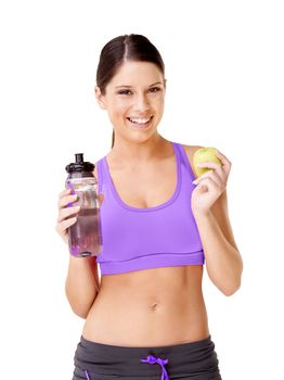 Eating right and keeping fit. a young woman in gym clothing holding.holding an apple and a water bottle isolated on white.